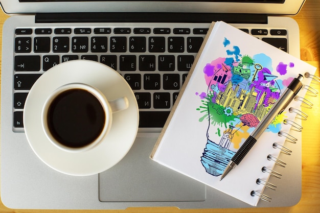 A collage of screenshots from popular budgeting apps and websites on a laptop screen, surrounded by pens, a notebook, and a cup of coffee.