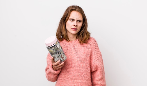 A person looking stressed while holding a stack of bills overlaid with a shattered glass effect, symbolizing financial emergency.