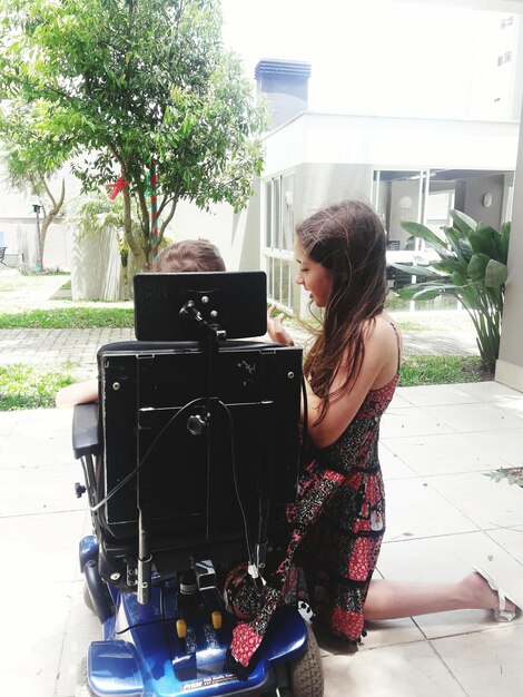 A person seated in a smart wheelchair maneuvering through a busy urban environment, showcasing the AI's ability to navigate crowded spaces and avoid obstacles. The focus is on the smooth and effortless movement of the wheelchair, highlighting the enhanced mobility and independence it provides.