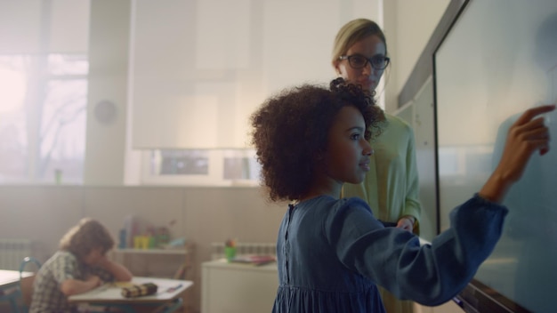 A teacher is guiding a group of students through an online lesson using interactive whiteboards and tablets. The students are actively participating, demonstrating how EdTech can foster a dynamic and engaging learning environment.