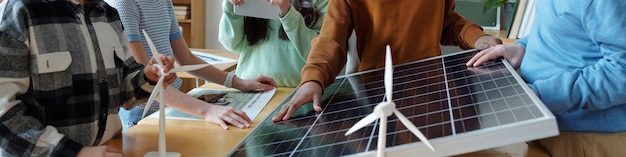A group of community members gathered around a solar microgrid installation, learning about its operation. The atmosphere is positive and collaborative.