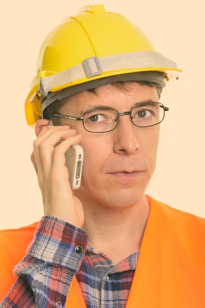 A close-up shot of a construction worker wearing a smart helmet with integrated sensors and a heads-up display showing real-time safety data and alerts. The focus is on the technology and its immediate application.