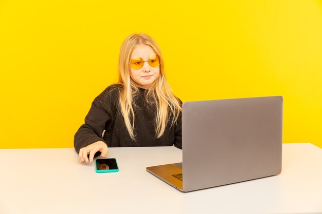 A person sitting at a desk, looking at a laptop screen displaying a flash sale advertisement with large 