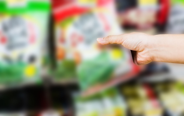 Close-up of a weekly supermarket ad featuring highlighted sales on fruits, vegetables, and dairy products. A hand points to a particularly attractive BOGO offer on cereal.