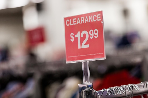 A close-up of a store policy sign at a US outlet mall, clearly stating discount rules or price matching guarantees. Focus is on highlighting the importance of understanding store policies for negotiation.