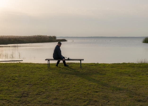 A person sitting alone on a park bench, looking stressed and isolated. The image captures a sense of loneliness and the impact of anxiety on social life.