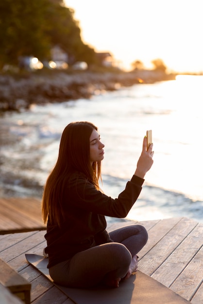 A person meditating in a quiet, peaceful setting, with a smartphone turned off in the background. The focus is on relaxation and mindfulness, highlighting the benefits of disconnecting from social media.