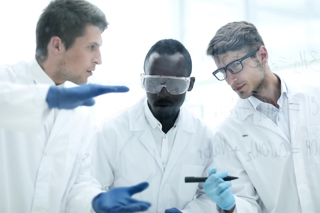 A close-up shot of researchers in a clean lab environment working on a cutting-edge carbon capture technology prototype. The atmosphere is focused and optimistic, with sophisticated equipment visible in the background.