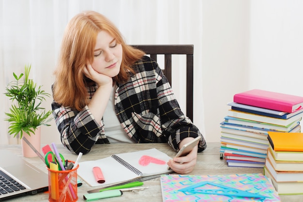 A student sitting at a desk with a laptop, surrounded by textbooks, notebooks, and pens. The student is using a budgeting app on the laptop to manage their finances. The image emphasizes the importance of financial planning for students.