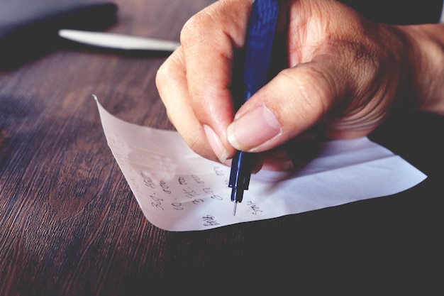 A close-up shot of a W-4 form being filled out, with a pen in hand and supporting documents like pay stubs and tax records surrounding it.