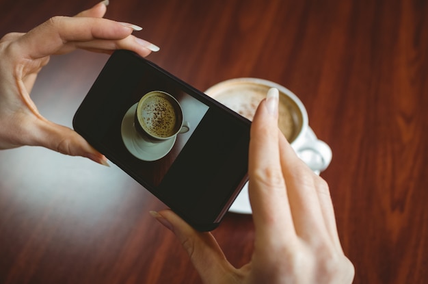 A close-up shot of a person donating cryptocurrency on a smartphone app, with a QR code displayed on the screen. In the background, there's a blurred image of a charity logo.